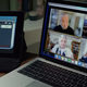 A Zoom call on a laptop, next to a tablet playing Among Us.
